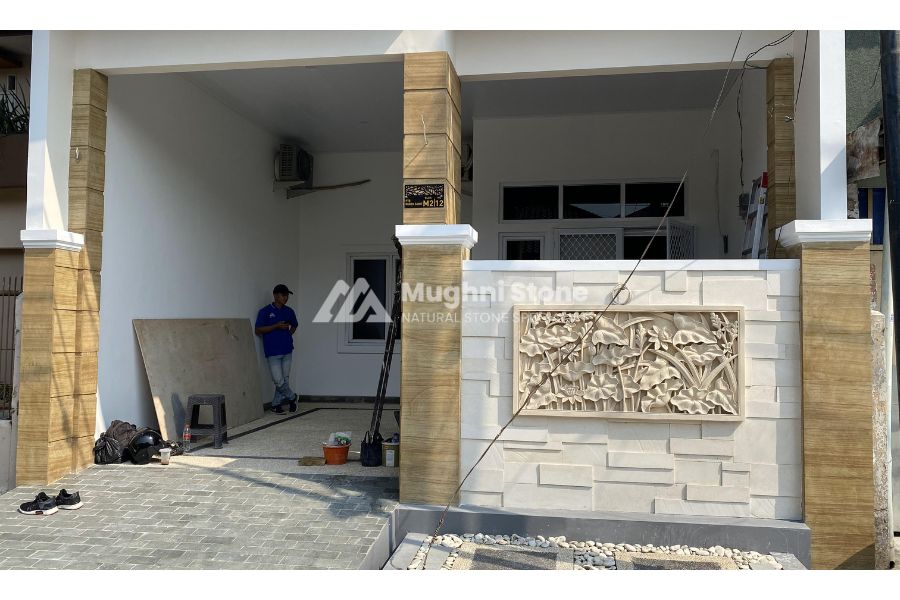 Pilar batu Bali Brown ukiran etnik dengan motif khas Bali di depan vila bergaya tropikal
